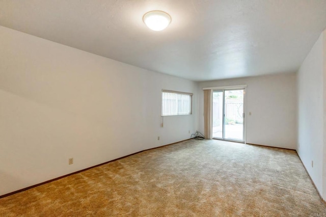 unfurnished room featuring carpet floors and baseboards