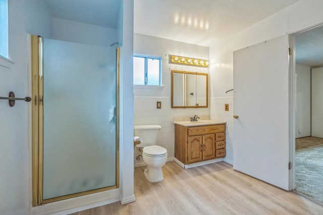 full bathroom featuring wood finished floors, toilet, a stall shower, and tile walls