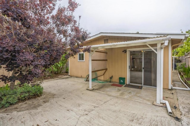 rear view of house featuring fence and a patio area