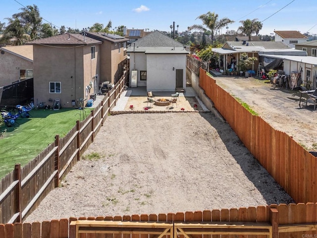 rear view of property with a fenced backyard, stucco siding, a patio area, and a residential view