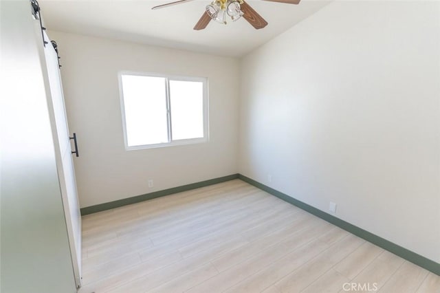 unfurnished room featuring light wood-style flooring, a ceiling fan, and baseboards