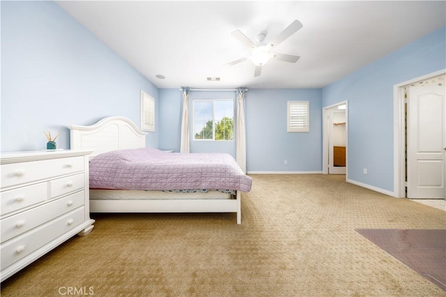 carpeted bedroom with baseboards, a ceiling fan, and visible vents