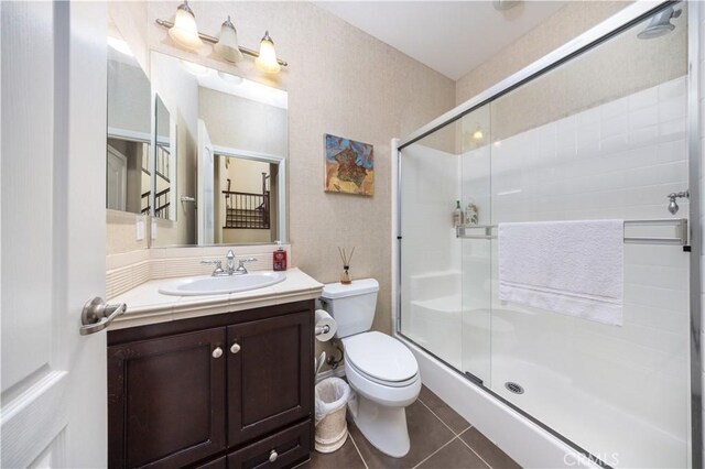 full bath featuring toilet, a stall shower, vanity, and tile patterned flooring