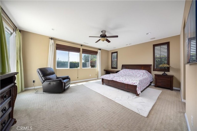 bedroom featuring baseboards, a ceiling fan, and light colored carpet