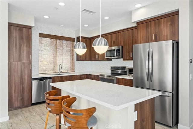 315 Mission Rd, Montebello, CA 90640 - kitchen with visible vents, a center island, a sink, hanging light fixtures, and stainless steel appliances