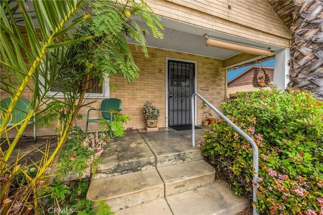 755 E 11th St, Pomona, CA 91766 - property entrance featuring covered porch and brick siding