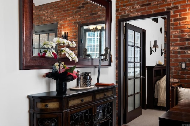 hall featuring carpet and brick wall