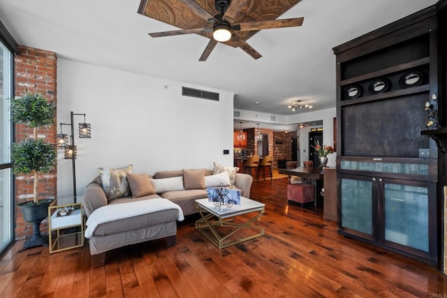 living room with a ceiling fan, visible vents, and hardwood / wood-style flooring