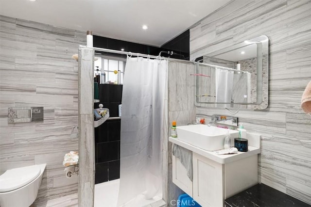 full bath featuring tile walls, toilet, vanity, and a tile shower