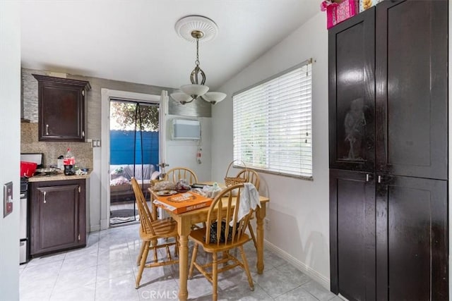 dining area with an inviting chandelier, a wall unit AC, baseboards, and light tile patterned floors