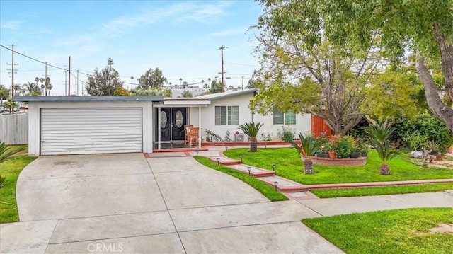 ranch-style home with stucco siding, concrete driveway, a front yard, and a garage