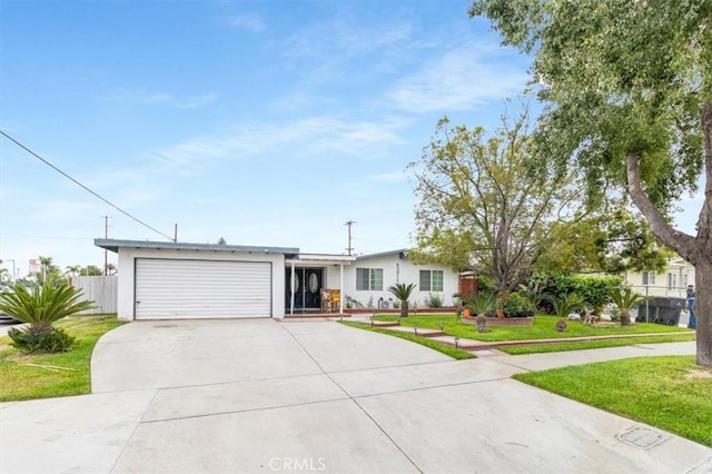 ranch-style house featuring a front lawn, driveway, fence, an attached garage, and stucco siding