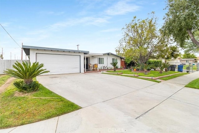 single story home with fence, a front lawn, concrete driveway, stucco siding, and a garage