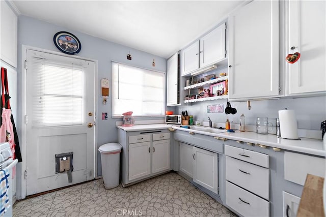 8824 Watson Ave, Whittier, CA 90605 - kitchen featuring light countertops, open shelves, light floors, stove, and a sink