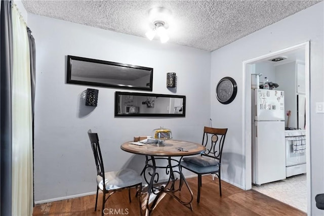8824 Watson Ave, Whittier, CA 90605 - dining space with baseboards, a textured ceiling, and wood finished floors