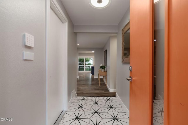 corridor with light tile patterned floors and baseboards