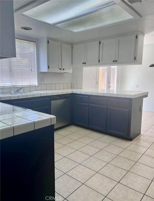 8109 Birch St, Bakersfield, CA 93311 - kitchen featuring stainless steel dishwasher, a sink, tile countertops, light tile patterned flooring, and a peninsula