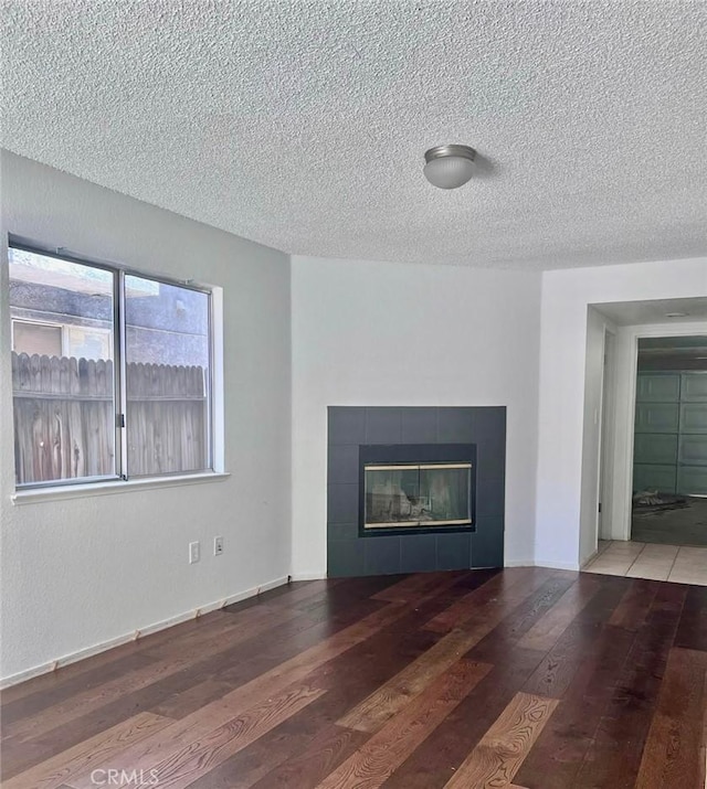 8109 Birch St, Bakersfield, CA 93311 - unfurnished living room featuring a tile fireplace, a textured ceiling, and wood-type flooring