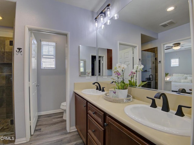 bathroom with wood finished floors, visible vents, a stall shower, and a sink