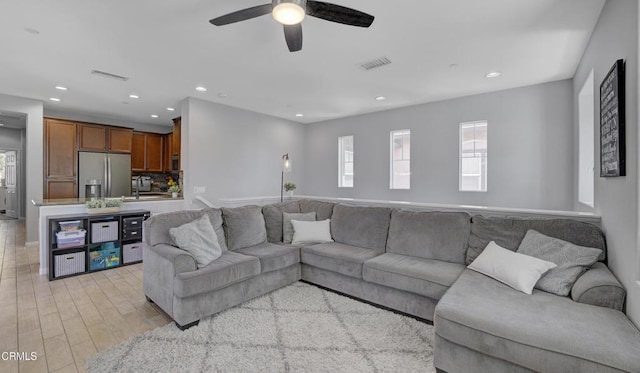 living room with ceiling fan, recessed lighting, visible vents, and light wood-type flooring
