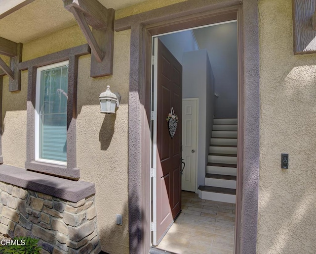 doorway to property featuring stucco siding