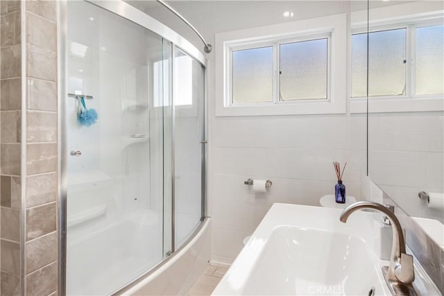 bathroom featuring a sink and tile walls