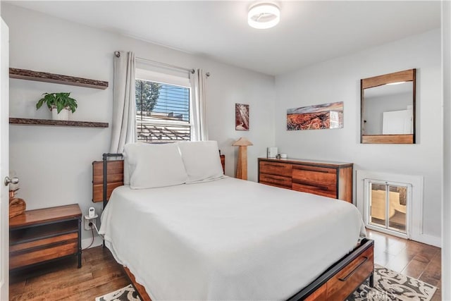 bedroom with access to exterior and wood finished floors