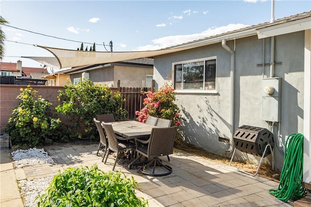 view of patio featuring outdoor dining space and fence