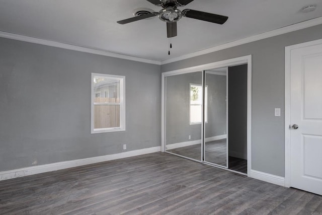 unfurnished bedroom with a closet, a ceiling fan, ornamental molding, wood finished floors, and baseboards