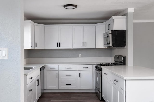 kitchen featuring dark wood-style flooring, light countertops, white cabinets, and stainless steel appliances