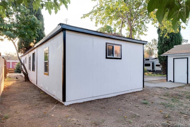 view of outbuilding featuring fence