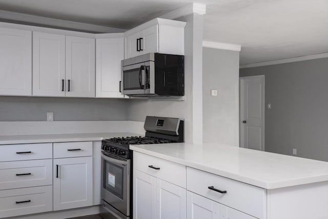 kitchen with a peninsula, light countertops, ornamental molding, and appliances with stainless steel finishes
