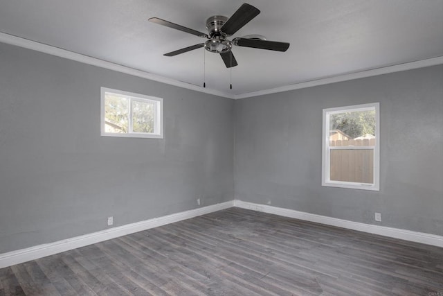 unfurnished room featuring a wealth of natural light, dark wood-style floors, baseboards, and ornamental molding