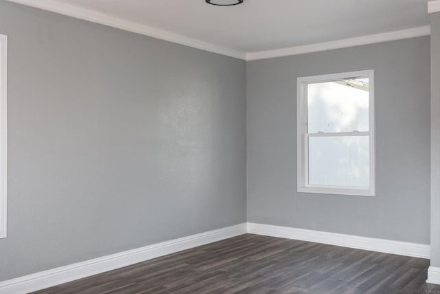 spare room with crown molding, baseboards, and dark wood finished floors