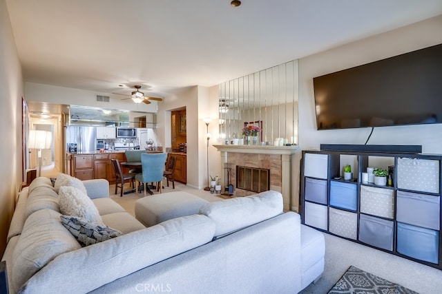 living area with light colored carpet, ceiling fan, and visible vents