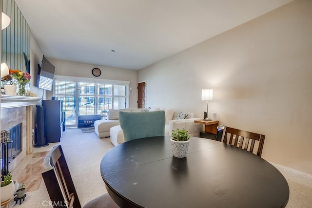dining room with baseboards and a fireplace