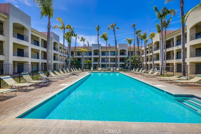 community pool featuring fence and a patio area