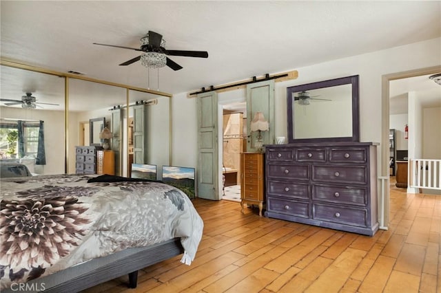 24540 Horst Dr, Crestline, CA 92325 - bedroom featuring visible vents, a closet, ceiling fan, light wood-type flooring, and a barn door