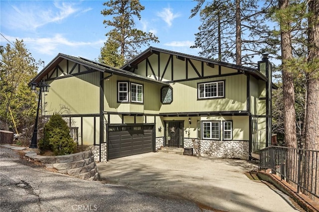 24540 Horst Dr, Crestline, CA 92325 - tudor home featuring a chimney, fence, aphalt driveway, an attached garage, and stone siding