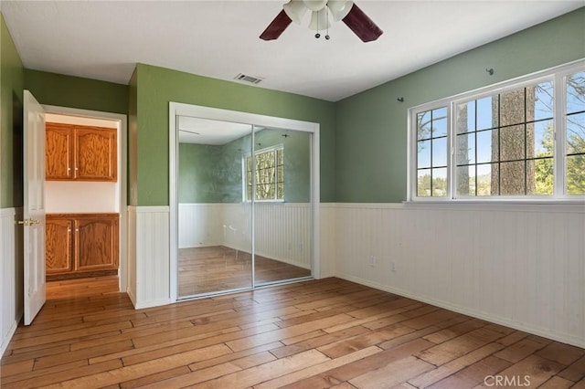 24540 Horst Dr, Crestline, CA 92325 - unfurnished bedroom featuring a wainscoted wall, a closet, light wood-style flooring, and visible vents