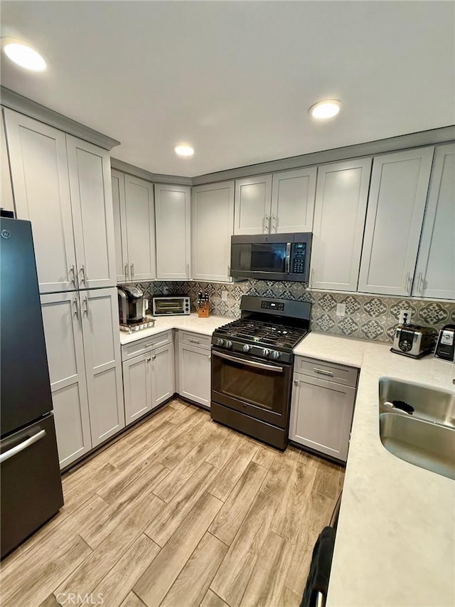 28236 Branch Rd, Castaic, CA 91384 - kitchen with a sink, light countertops, gray cabinets, light wood-type flooring, and black appliances