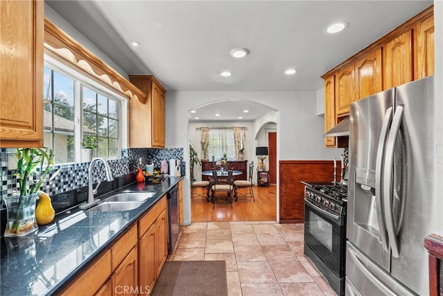 1435 W 50th St, Los Angeles, CA 90062 - kitchen featuring stainless steel fridge with ice dispenser, range with gas cooktop, arched walkways, a sink, and recessed lighting