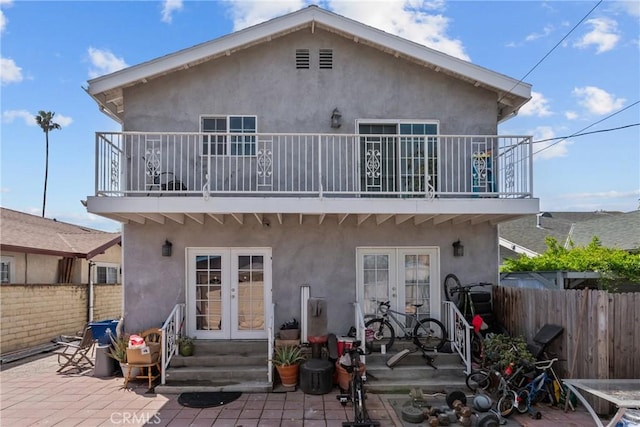 1435 W 50th St, Los Angeles, CA 90062 - rear view of house with french doors, a balcony, stucco siding, and a patio