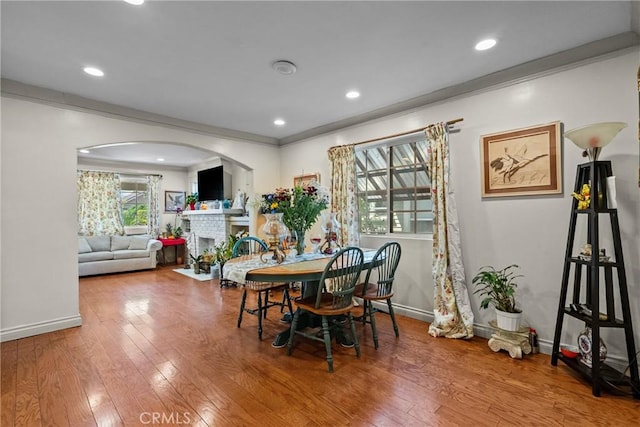 1435 W 50th St, Los Angeles, CA 90062 - dining room featuring hardwood / wood-style floors, arched walkways, baseboards, a fireplace, and recessed lighting