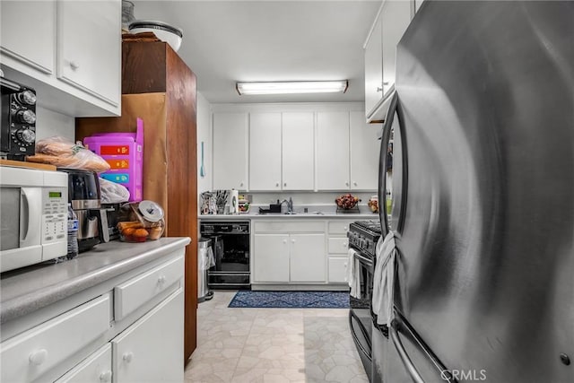 kitchen featuring light countertops, a sink, white cabinetry, and black appliances