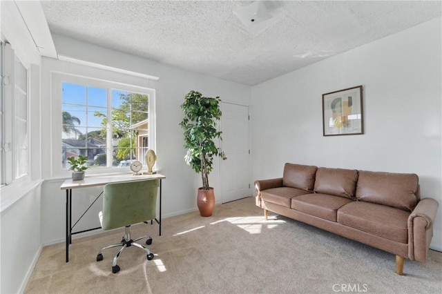 office area with baseboards, a textured ceiling, and carpet flooring