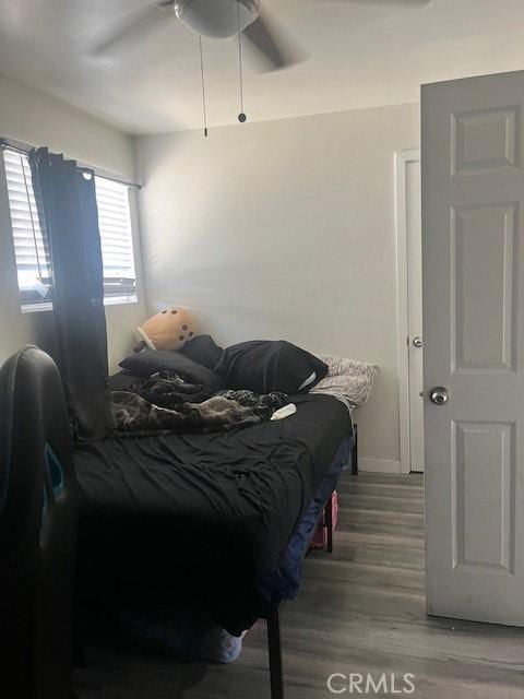 bedroom with baseboards, a ceiling fan, and wood finished floors