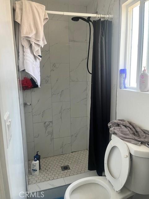 full bathroom with a stall shower and toilet