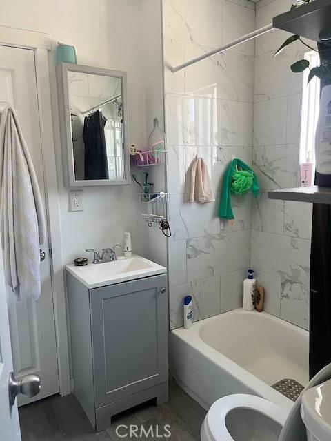 full bathroom featuring vanity, bathtub / shower combination, and toilet