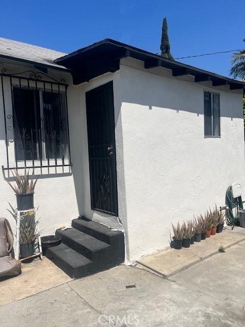 doorway to property featuring stucco siding